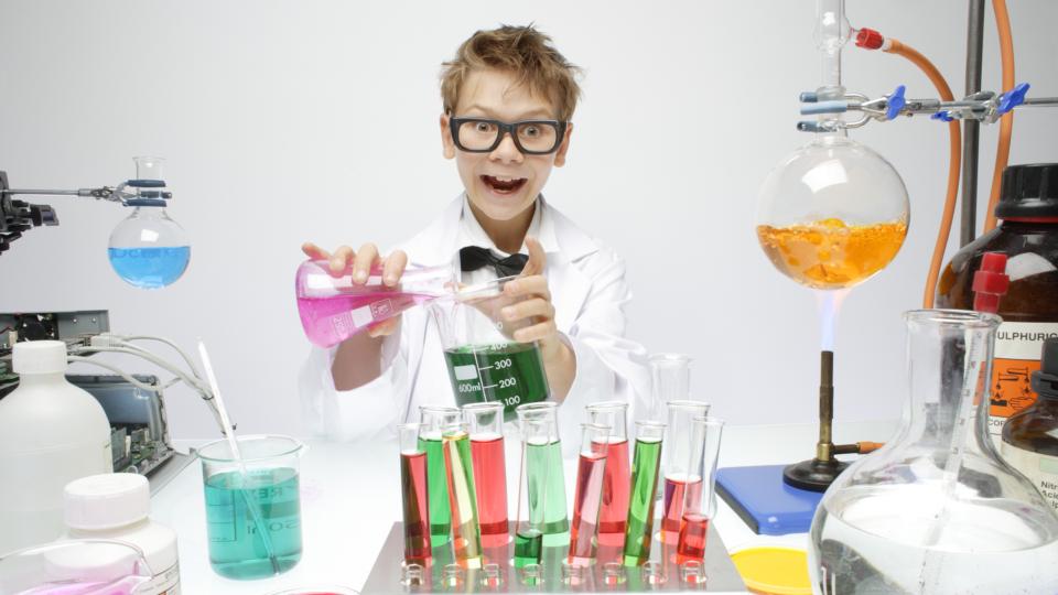 child completing science experiment with beakers